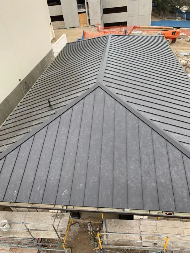 Commercial metal roof construction with crane equipment in Tualatin